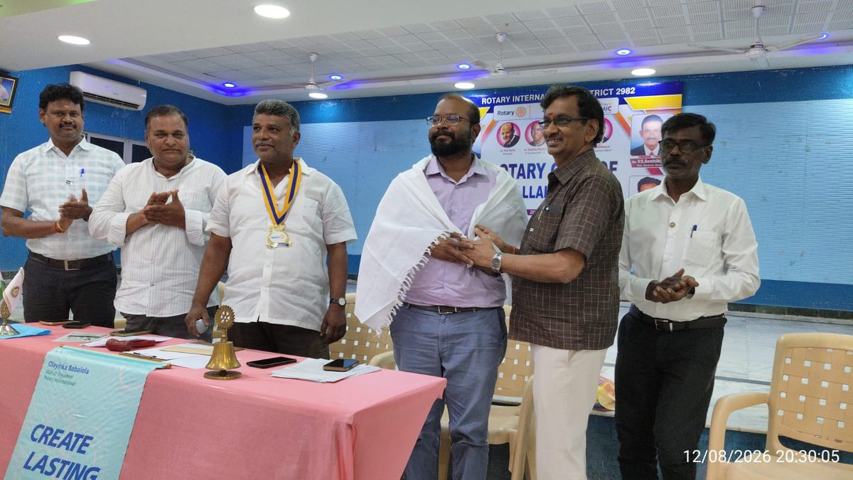 Members standing for the national anthem at the Rotary Club of Kallakurichi meeting